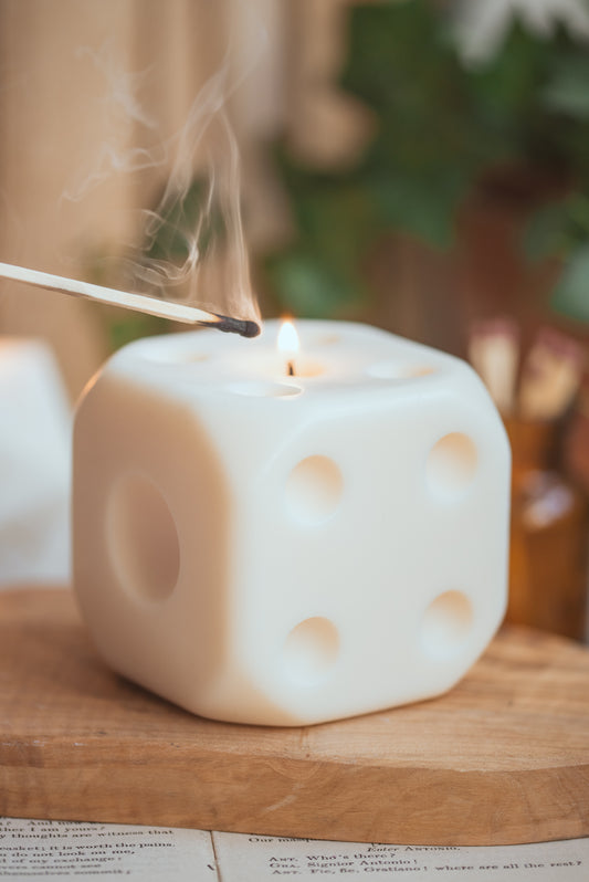 Lit D6 dice candle on table