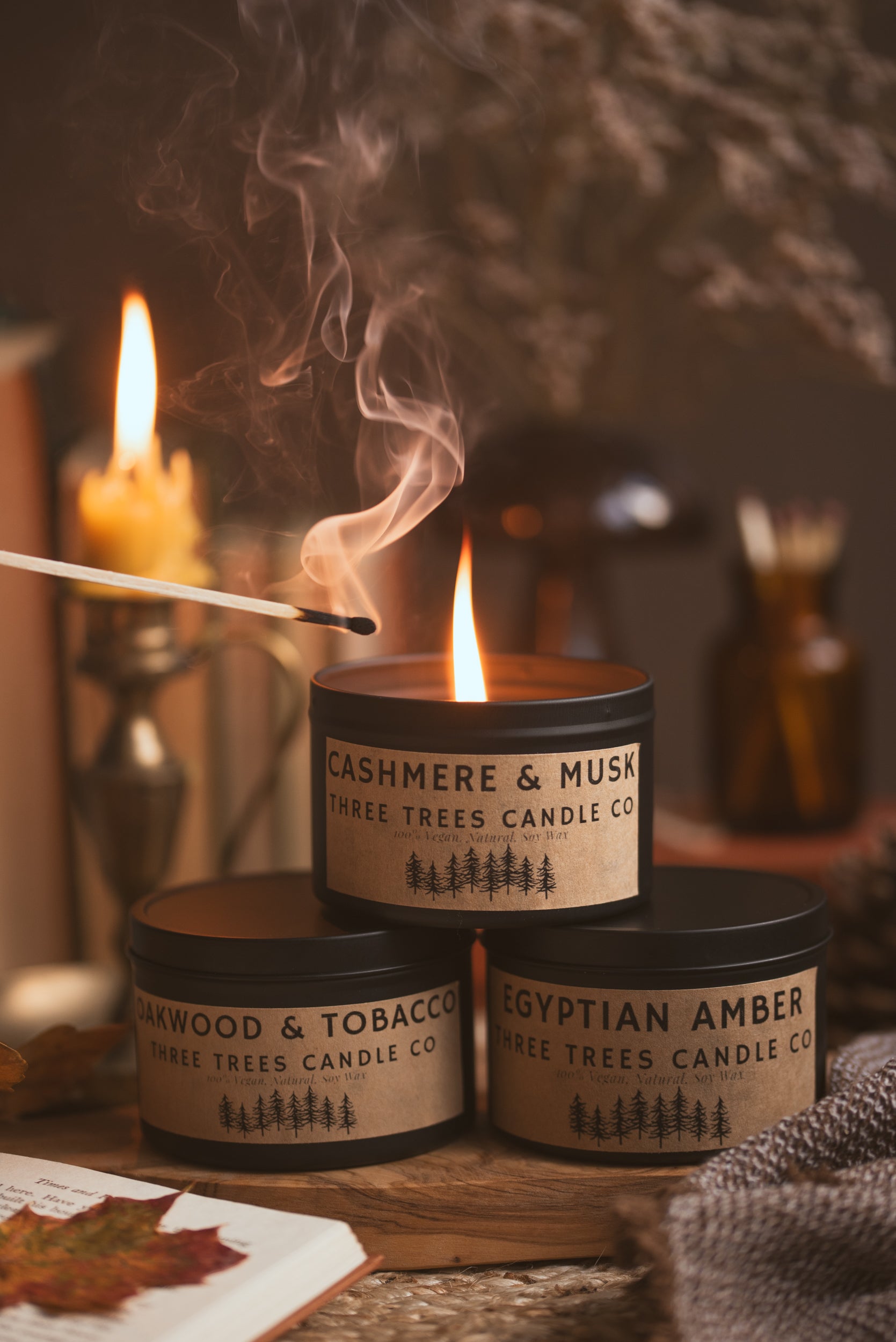 Autumn scented cosy candles styled on table with cozy home decor