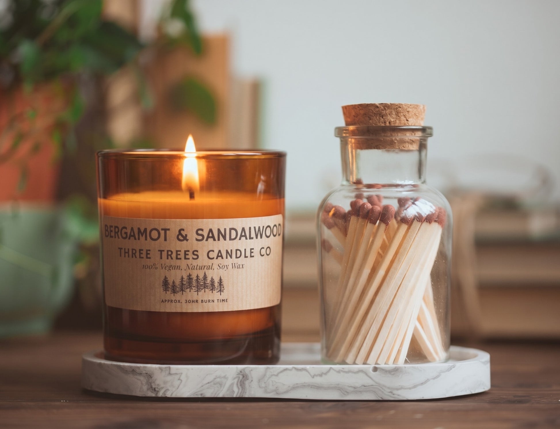 bergamot and sandalwood scented candle on tray amber glass