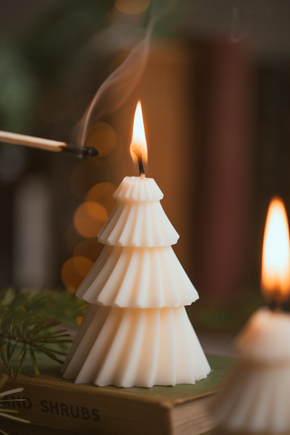Close-up of tiered minimalist Christmas tree candle showing layered wax design