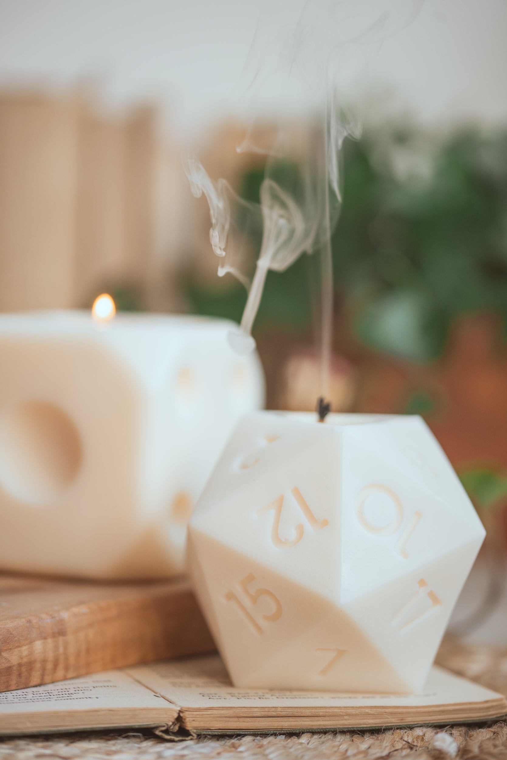 D20-shaped candle styled on table with RPG accessories