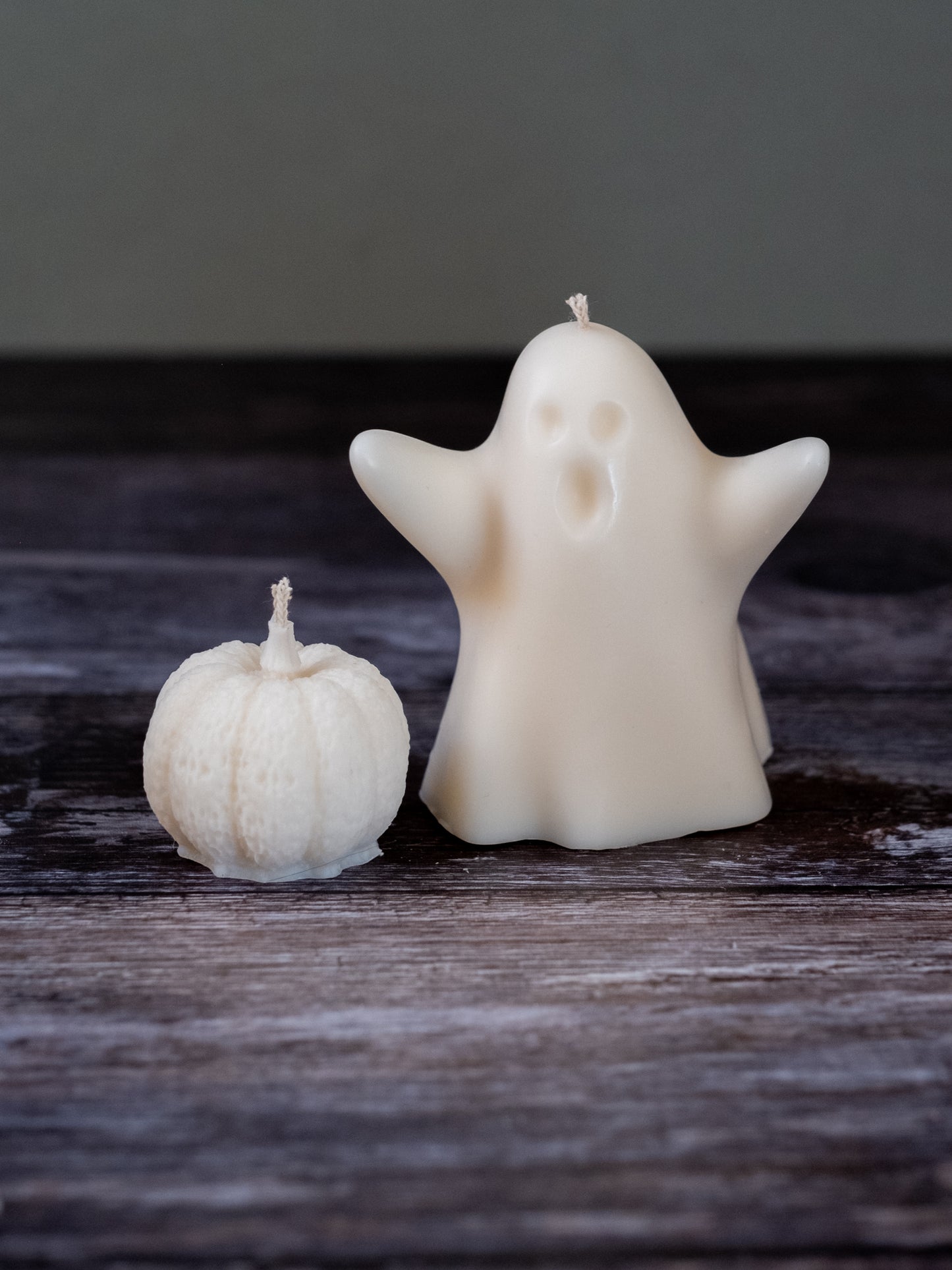 Ghost-shaped candle styled on table with Halloween decor