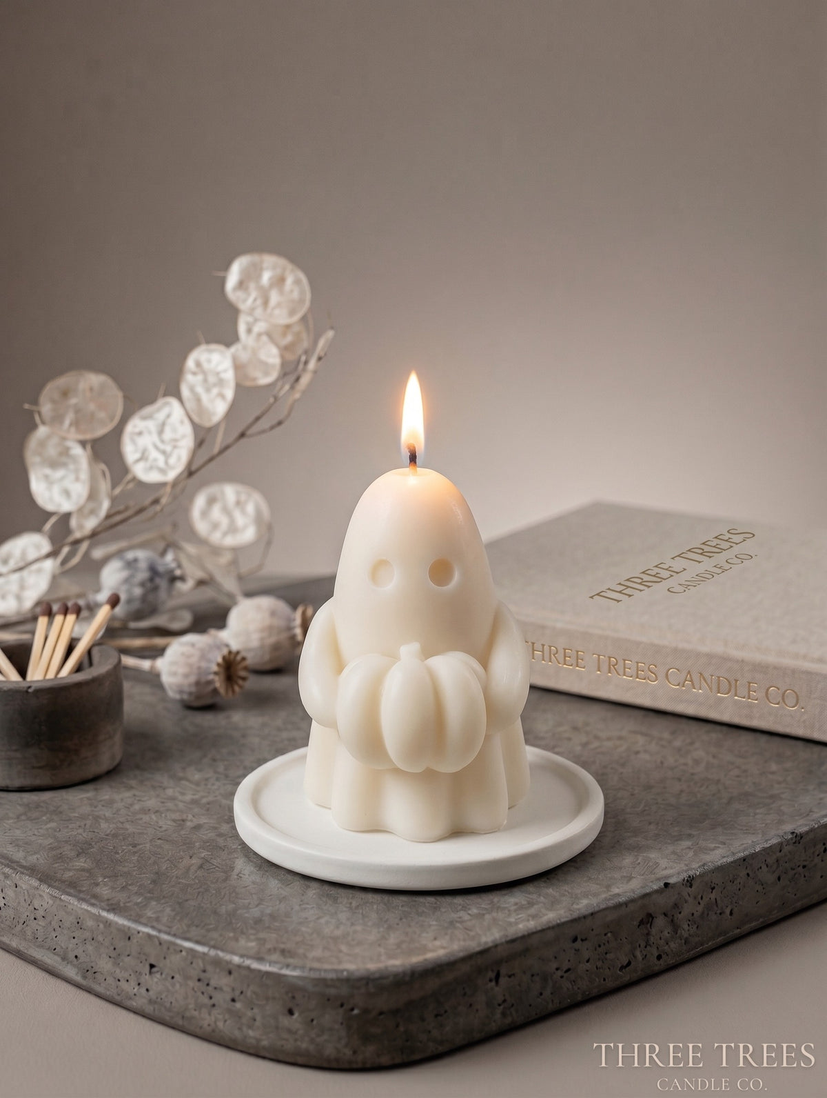 Ghost holding a pumpkin shaped soy wax decorative candle.