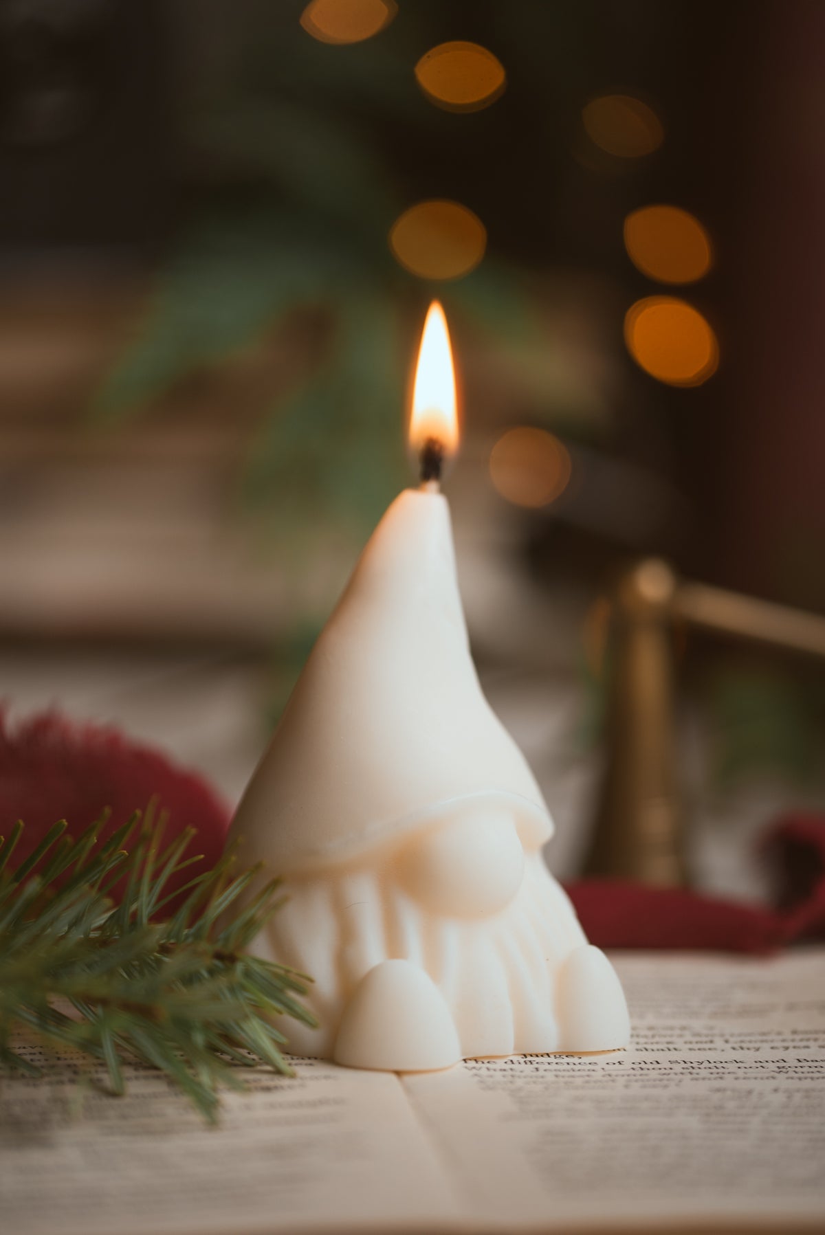 Lit gonk-shaped soy candle creating warm holiday ambiance
