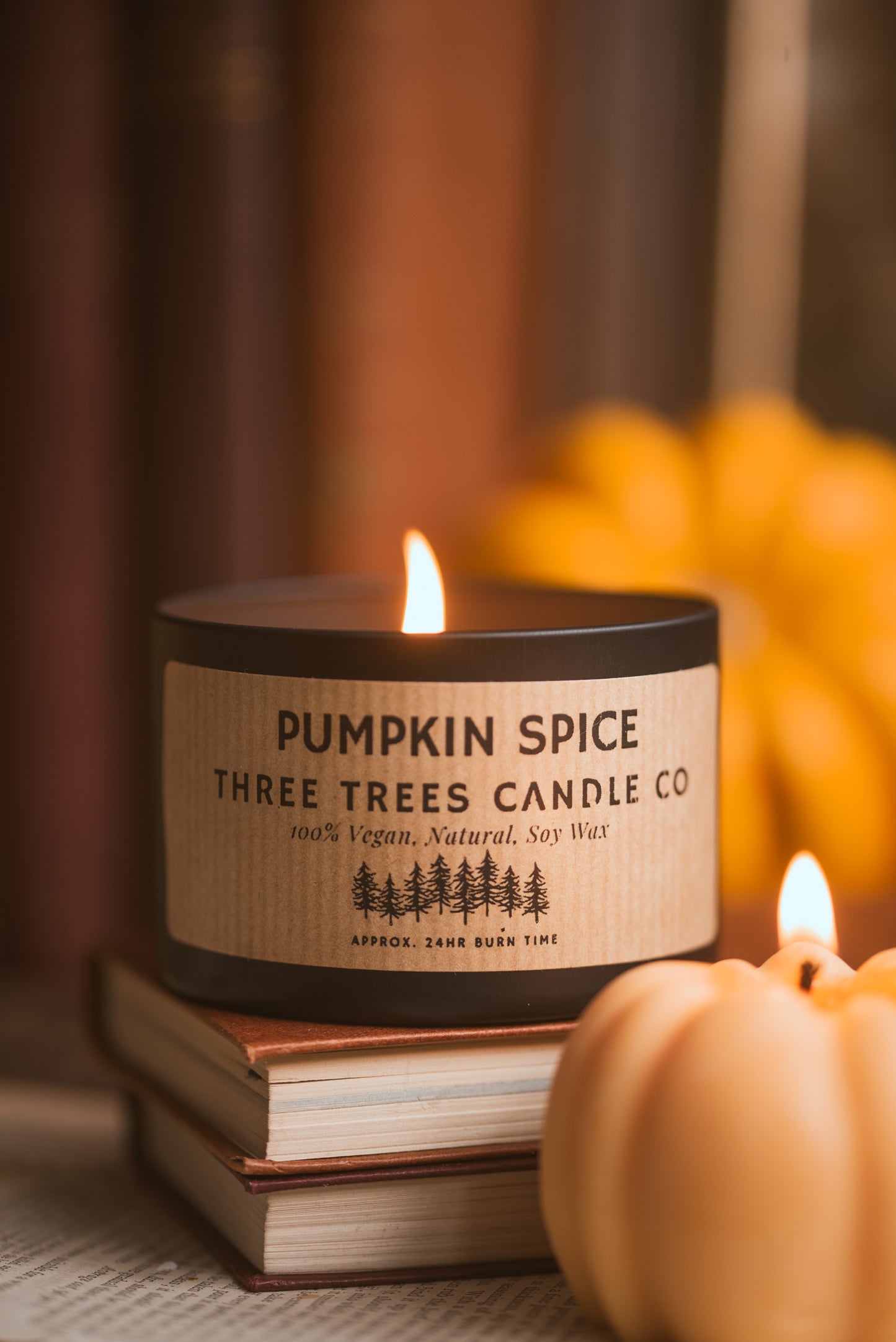 Lit pumpkin spice candle creating cozy fall ambiance