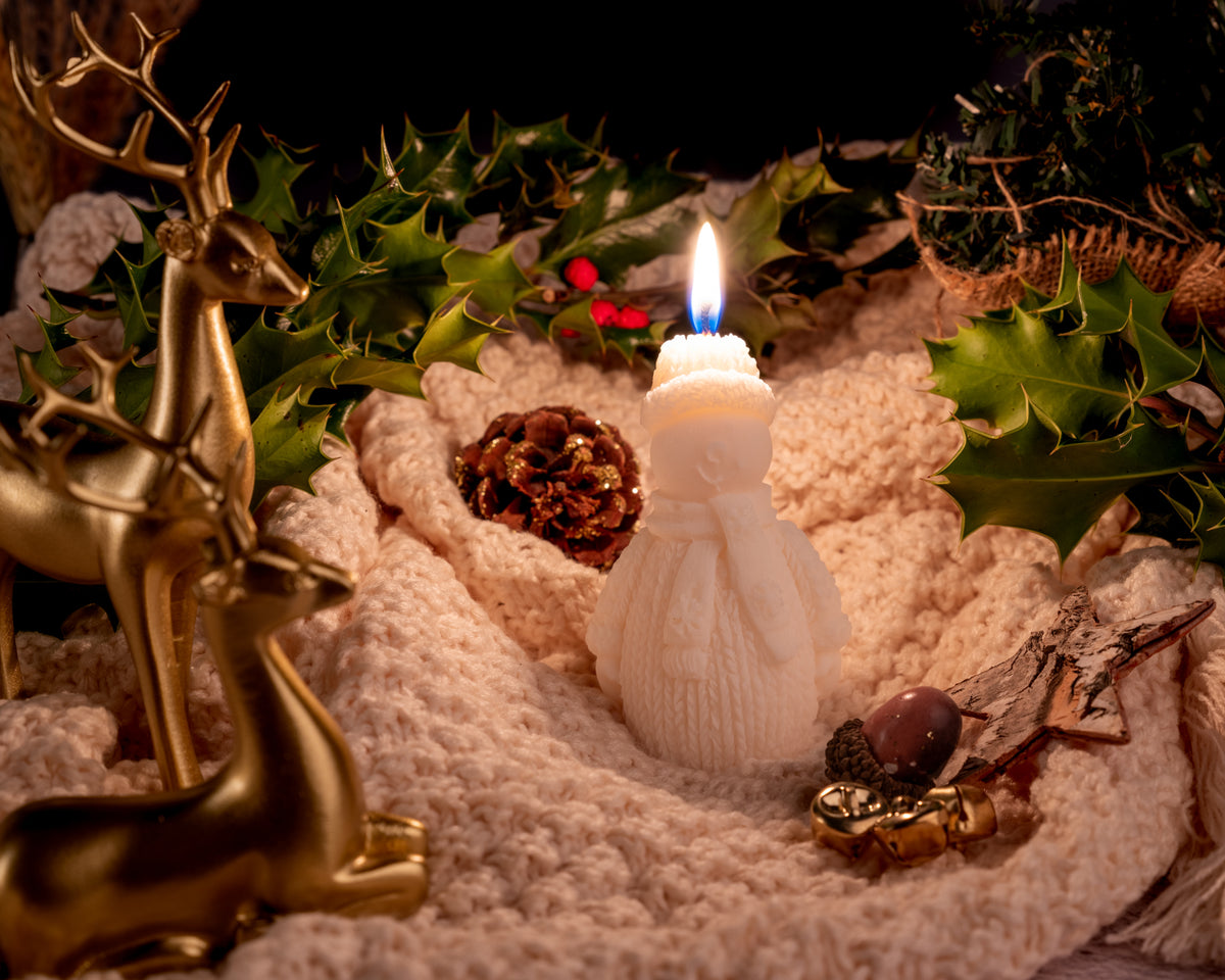 Lit snowman-shaped soy candle creating cozy winter ambiance