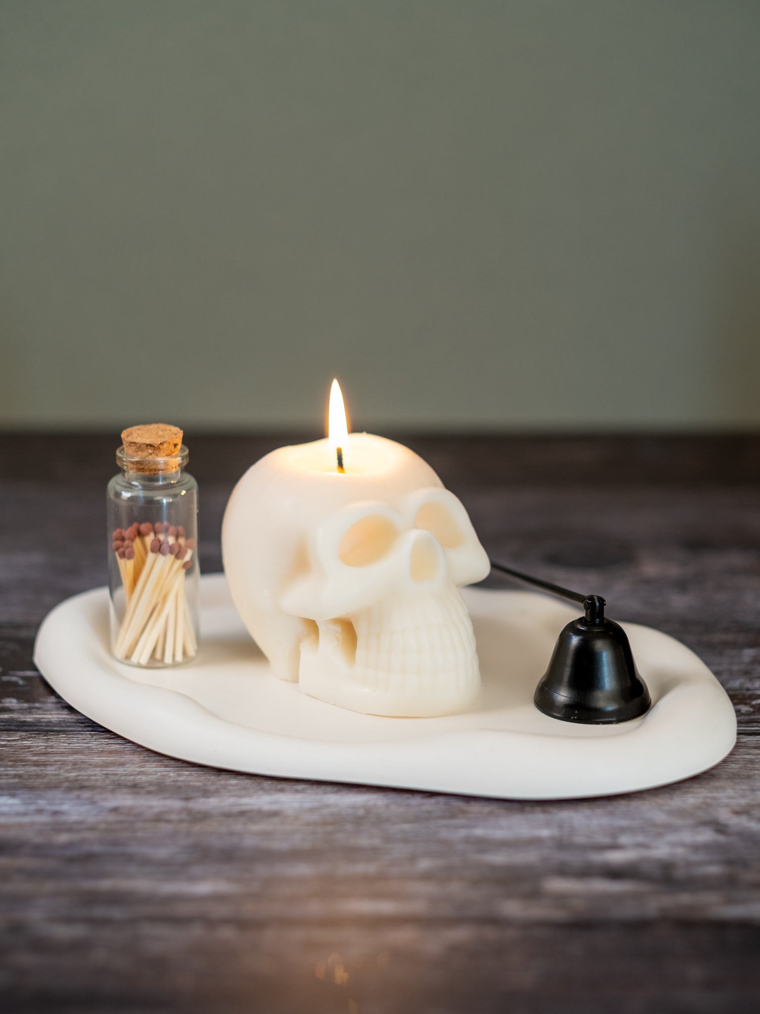 Skull-shaped candle styled on table with gothic decor