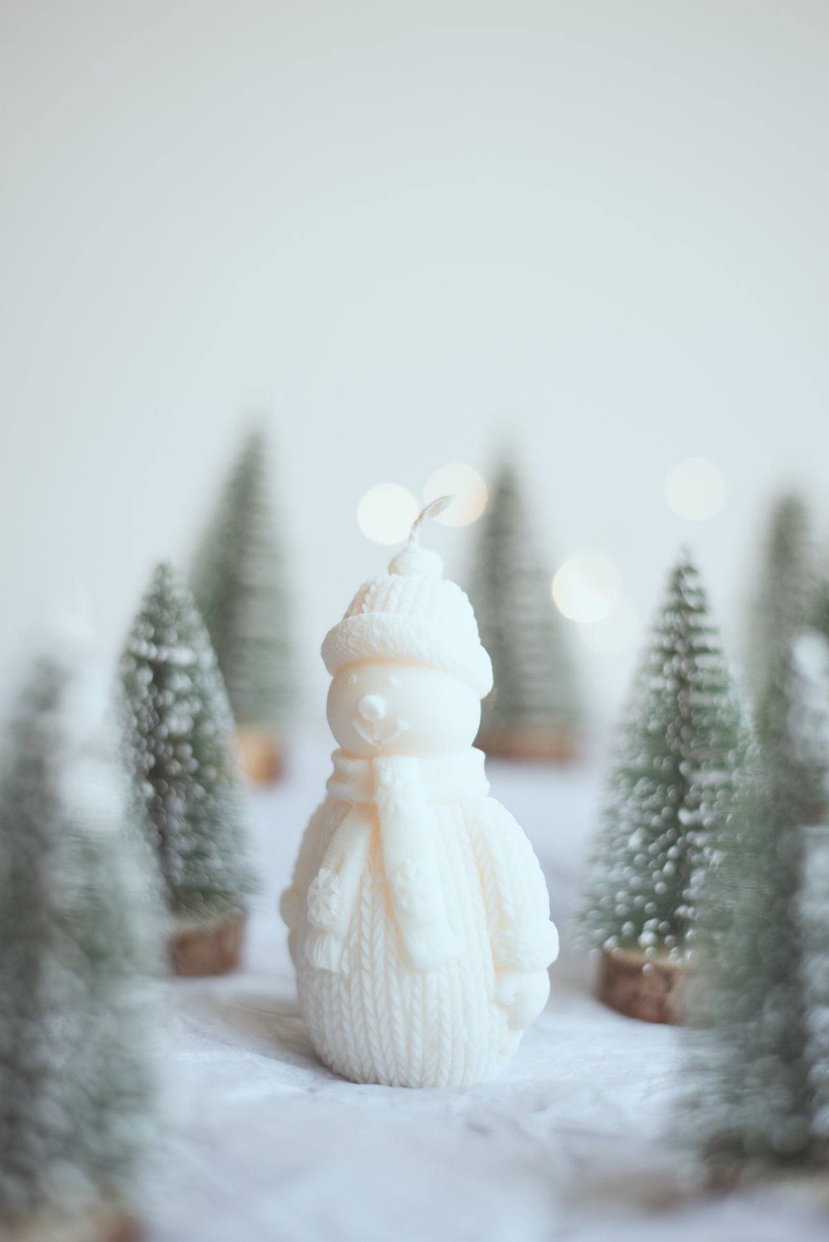Snowman-shaped candle styled with Christmas home decor